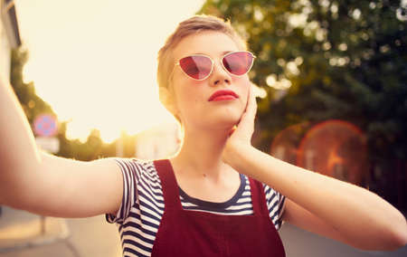 pretty woman with glasses and a sundress walking down the street autumnの写真素材