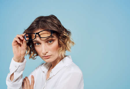 Fashionable woman in glasses and blue background white shirt Copy Space