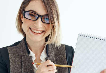 Portrait of a business woman in a suit with documents in hands on a light backgroundの写真素材