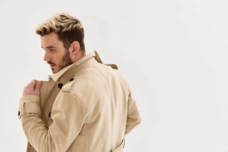 bearded man with fashionable hairstyle beige coat modern styleの写真素材