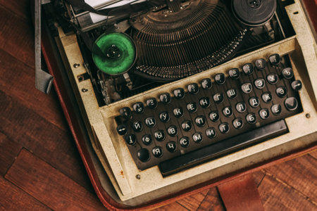 vintage typewriter with keys on a wooden background and a white sheet of paper