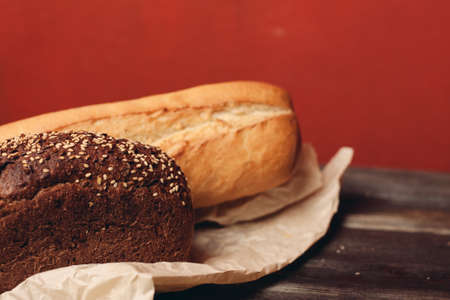 flour products rye bread on packaging and wooden table knife red backgroundの写真素材