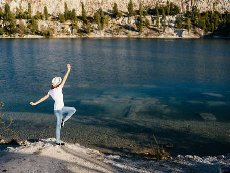 Energetic woman traveler near the river on nature in the mountainsの写真素材