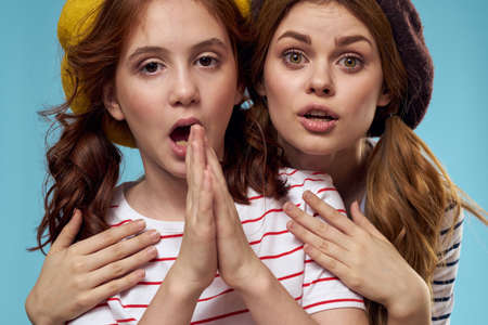Cheerful girl and woman on a blue background sisters family emotions