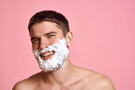 Man with bare shoulders clean skin face care pink backgroundの写真素材