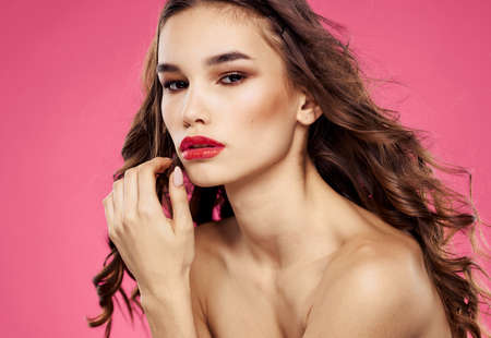 Sexy brunette model pink background red lips bared shouldersの写真素材