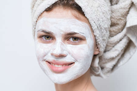 beautiful woman with white mask against black dots on her faceの写真素材