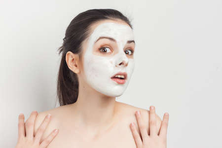 woman with bare shoulders with makeup on face skin care cream rejuvenationの写真素材