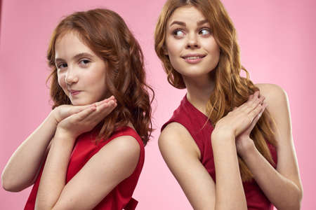 Mom and daughter fun communication family joy pink background cropped view