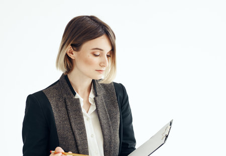 Woman in a suit In a bright room with documents in handsの写真素材