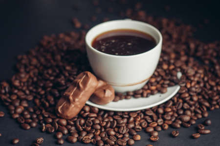 a cup of coffee and a chocolate bar on a saucer arabica beans variety drinkの写真素材