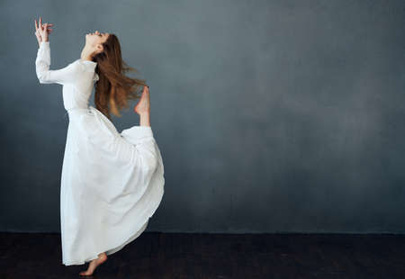 Romantic red-haired Woman in a white dress on a gray background Copy Spaceの写真素材