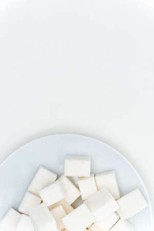 granulated sugar cubes on a plate sweets light background