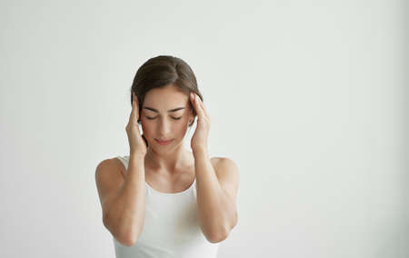woman with a cold holding her head flu health problemsの写真素材