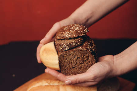 flour products in female hands and sliced baguette on a boardの写真素材