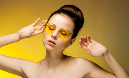 pretty brunette naked shoulders yellow glasses glamor studioの写真素材