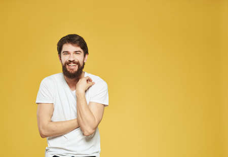 male model gesturing with his hands on a yellow background cropped view Copy Spacの写真素材