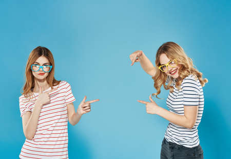 Two girlfriends striped T-shirts fashion emotions communication conflict quarrelの写真素材