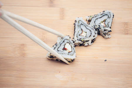 triangular sushi rolls chopsticks wood board japanese cuisineの写真素材