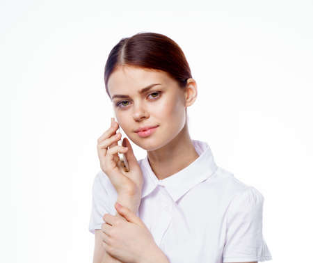 pretty woman in shirt with phone in hands technology secretary officeの写真素材