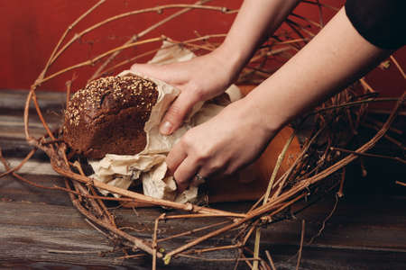 rye bread in a nest on a wooden table on a red backgroundの写真素材