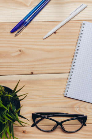 desk notepad pens stationery business office wooden tableの写真素材