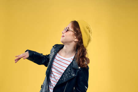 Girl in a yellow hat dark glasses fashionable clothes studio lifestyle childhoodの写真素材