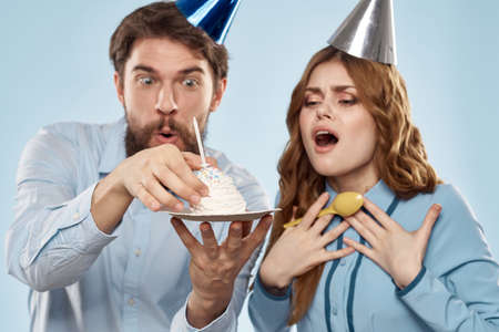 Party man and woman birthday cake corporate fun blue backgroundの写真素材