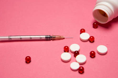 Open jar with pills on pink background coldspace top viewの写真素材