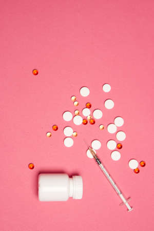 Open jar with pills on pink background coldspace top viewの写真素材