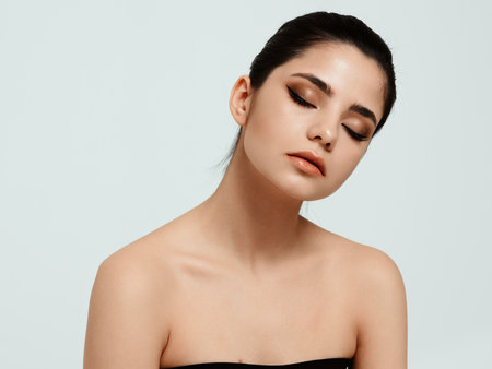 woman with bare shoulders and makeup on face light background cropped viewの写真素材