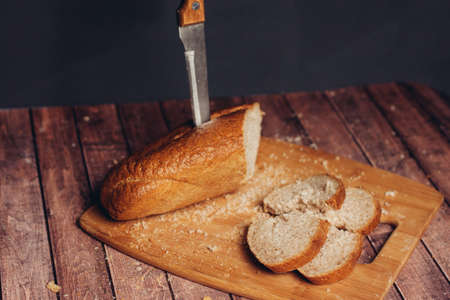 slicing a loaf on a cutting board kitchen eating breakfast fresh smellの写真素材