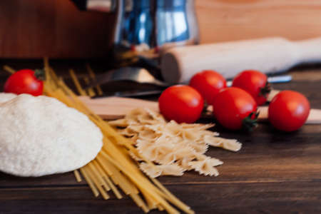 ingredients for italian pasta cherry tomatoes cutting boardの写真素材