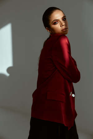 pretty woman in red jacket fashion studio light backgroundの写真素材
