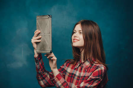 woman with tablet in hand on blue background plaid shirt red hair modelの写真素材