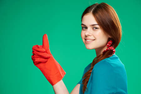 cheerful cleaning lady gesturing with her hand rubber gloves houseworkの写真素材