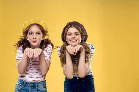 Mom and daughter embrace joy fun childhood lifestyle yellow backgroundの写真素材