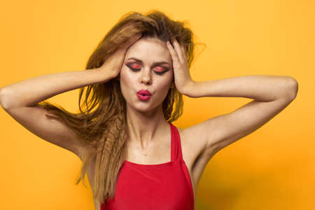emotional woman wavy hair bright makeup lifestyle yellow backgroundの写真素材
