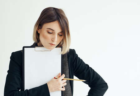 Beautiful woman in jacket with dad documents white sheet of paper mockupの写真素材