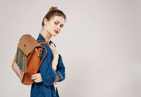 beautiful cheerful woman with backpack student training clothes fashion gray backgroundの写真素材