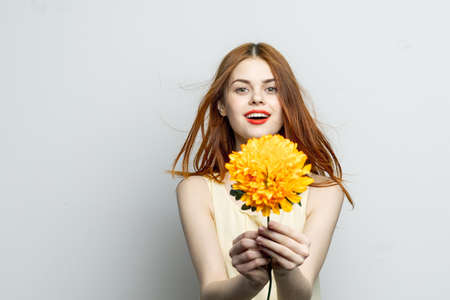 woman red lips yellow flower in hands of charm gift lifestyleの写真素材