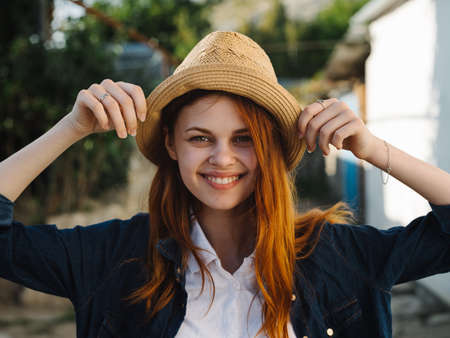 Happy woman in hat red hair shirt model countrysideの写真素材
