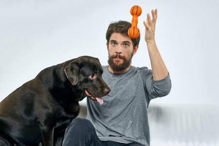 man at home with purebred dog on the couch friendship funの写真素材