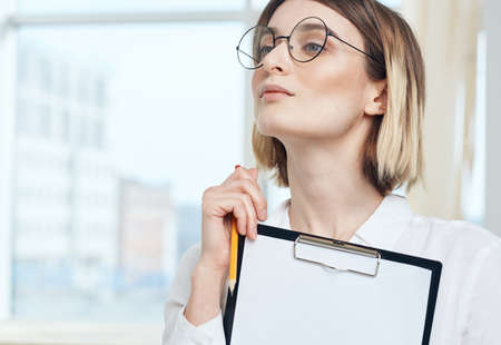 portrait of business woman with white sheet of paper in finance folder