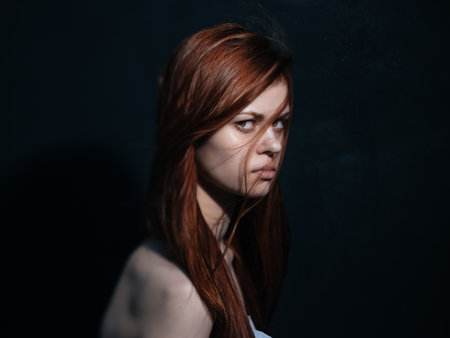 Romantic woman with red hair on a dark background model close-up portrait