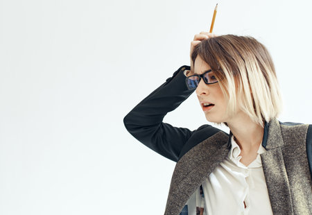 A woman in a suit with a pencil in her hands on a light background business financial director of the firmの写真素材