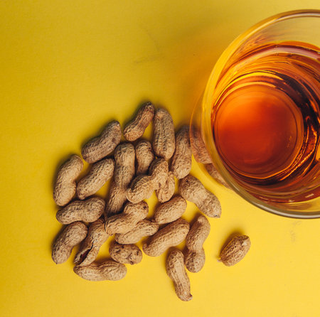 peanuts in shells beer mug snack alcohol yellow backgroundの写真素材