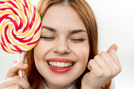 cheerful pretty woman with big multicolored lollipop smile sweets dessertの写真素材