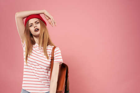 beautiful woman in fashion clothes red hat cropped view pink backgroundの写真素材