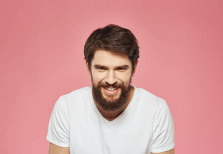 Portrait of a cheerful man on a pink background emotions cropped viewの写真素材